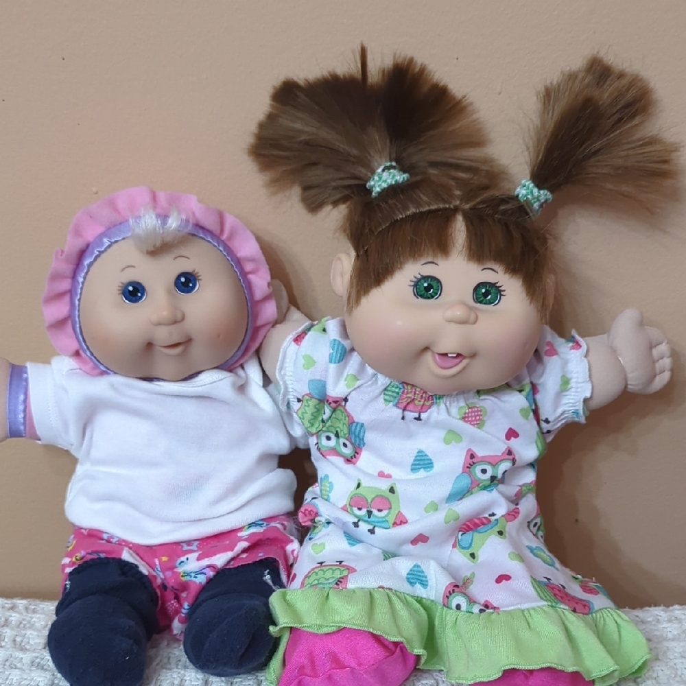 Cabbage Patch Babys in their PJs. 1 with Brown Hair the other has Blonde Curl